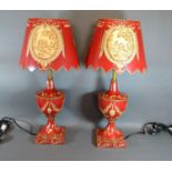 A Pair of Toleware Table Lamps each with cream decoration upon a red ground, 55 cms tall