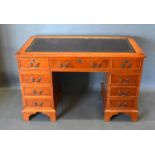 A 20th Century Twin Pedestal Desk, the tooled leather inset top above nine drawers with brass