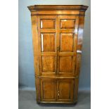 A George III Oak Standing Corner Cabinet, the moulded cornice above two moulded doors enclosing