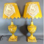 A Pair of Toleware Table Lamps with cream decoration upon a mustard ground, 56 cms tall