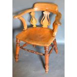 An Early 19th Century Elm and Oak Captain's Armchair with shaped rounded arms and pierced splat back