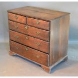 A George III Oak Chest of two short and three long drawers with brass handles and escutcheons raised