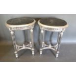 A Pair of French Style Silvered Oval Lamp Tables, the marble tops above a carved frieze raised