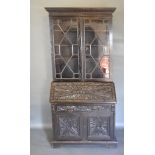 A Victorian Carved Oak Bureau Bookcase, the moulded cornice above two astragal glazed doors