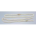 A Cultured Pearl Necklace with 9ct. Gold Clasp, 43 cms long together with another similar cultured