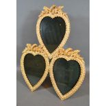 A Gilt Metal Triple Photograph Frame of heart form with torch and quiver cresting 25cm by 31cm tall