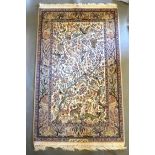 An Isfahan Silk Pictorial Rug with exotic birds and animals amongst foliage within multiple