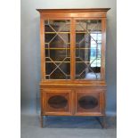 An Edwardian Mahogany Bookcase, the moulded cornice above two astragal glazed doors enclosing