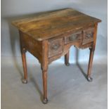 A George III Oak Low Boy, the moulded top above three frieze drawers with brass handles and shaped