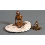A Small Bronze Figure of a Seated Lady upon a Stone, 7 cms tall together with a small bronze model