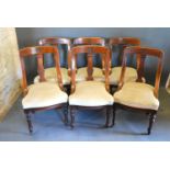 A Set of Six Victorian Walnut Dining Chairs, the carved backs above stuff over seats raised upon