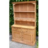 A Pine Dresser, the boarded shelf back with four drawers, the lower section with two drawers above