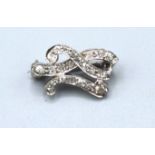 A White Metal Diamond Set Small Brooch of scroll form, 2 cms long