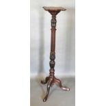 A 19th Century Mahogany Torchere, the shaped top above a carved centre column raised upon