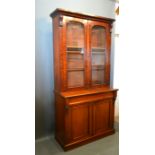 A Victorian Mahogany Bookcase, the moulded cornice above two glazed doors, the lower section with