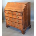A George III Oak Bureau, the fall front enclosing a fitted interior above four long drawers with