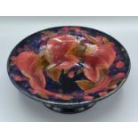 A William Moorcroft footed bowl decorated in the pomegranate pattern upon a mottled blue ground,