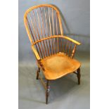 An Early 19th Century Elm Windsor Armchair, the shaped stick back above a panel seat raised upon