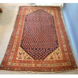 A North West Persian Woollen Rug with an all over design upon a red, blue and cream ground within