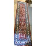 A North West Persian Woollen Runner with an all over design upon a red blue and cream ground