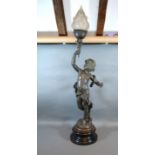 A Patinated Spelter Table Lamp in the form of Putti holding a torch with opaque glass shade 101