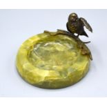 A Patinated Bronze Model of a Bird perched on a branch upon an onyx dish, 7 cms tall