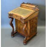 A Victorian burr walnut Davenport, the stationary compartment above a leather writing surface,