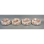 A set of four silver plated bottle coasters of pierced form with cherubs amongst foliage and with