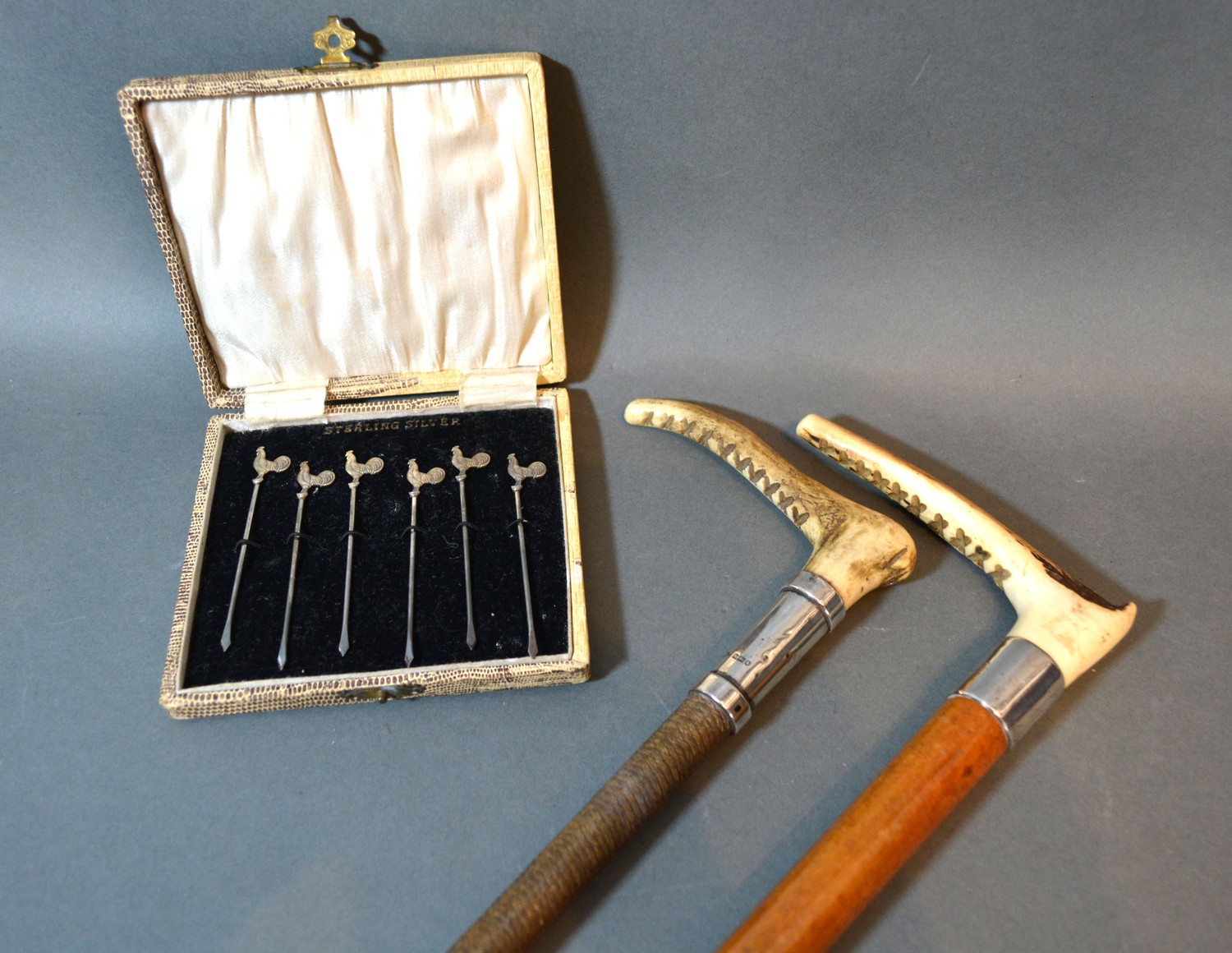 A set of six Sterling silver cocktail sticks in case and two silver mounted riding crops