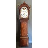 A 19th century mahogany long case clock, the arched hood above a shaped door, raised upon bracket