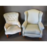 A 20th century wingback armchair together with a similar tub shaped chair