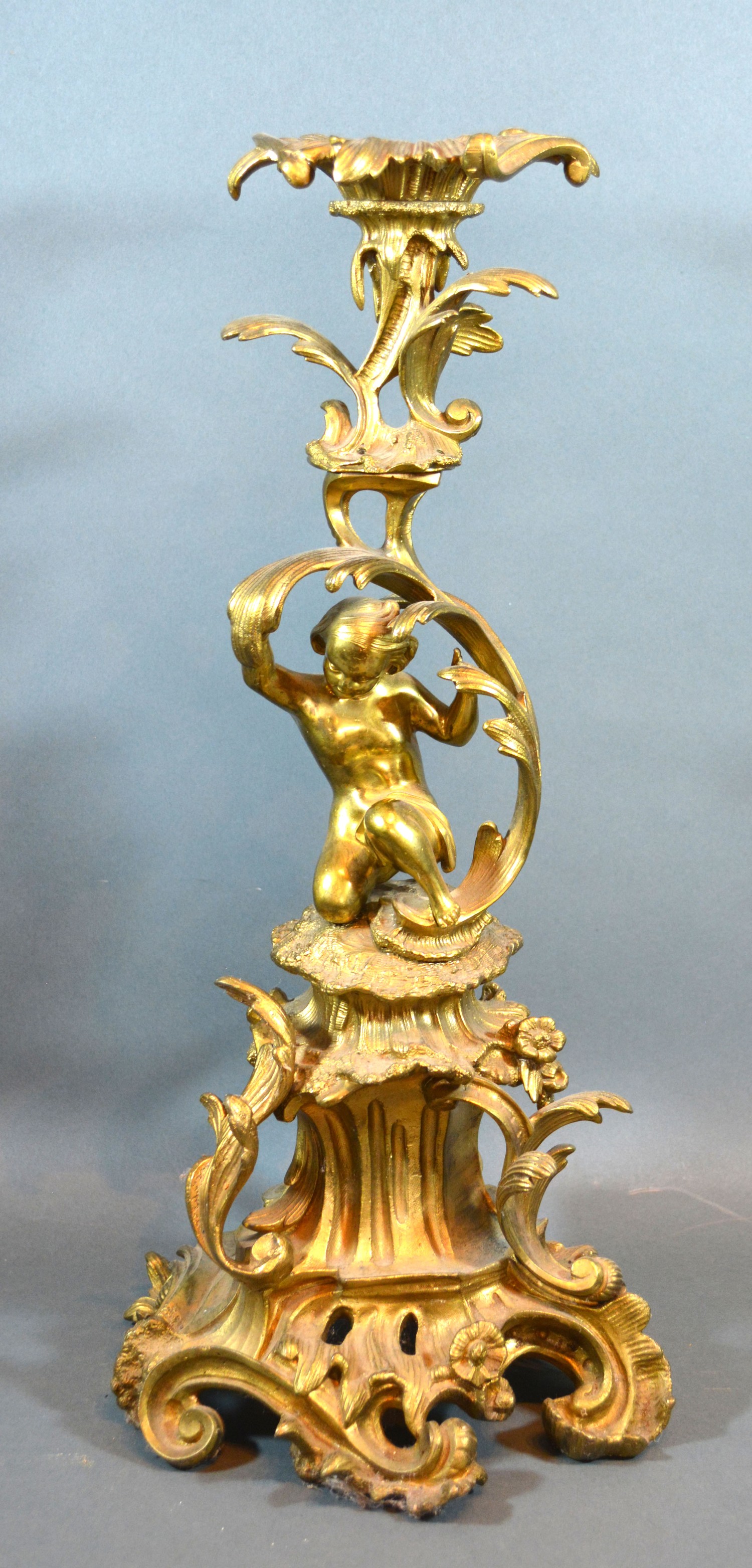 A late 19th early 20th century French table centre of scroll form mounted with putti 50cm tall