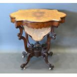 A Victorian burr walnut work table, the shaped hinged top enclosing a fitted interior above a fabric