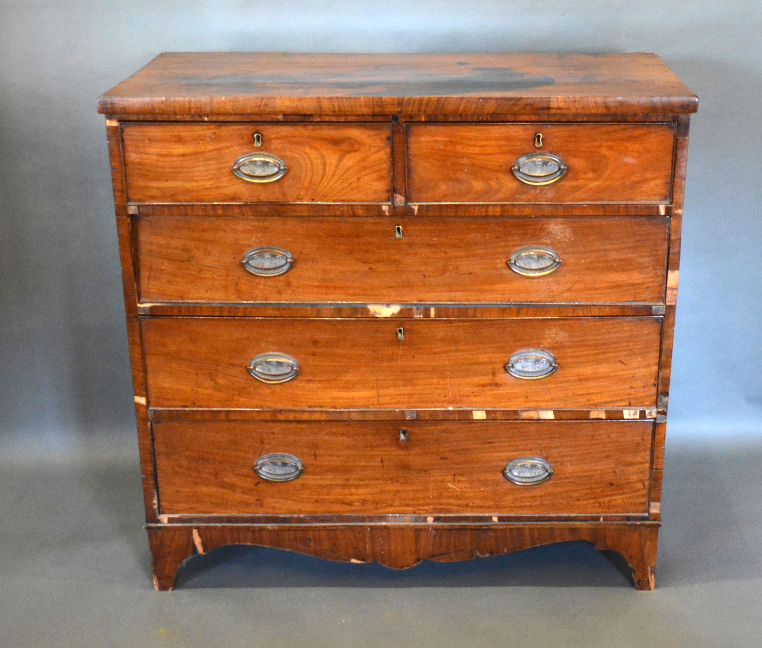 A 19th century mahogany straight front chest of two short and three long drawers with oval brass