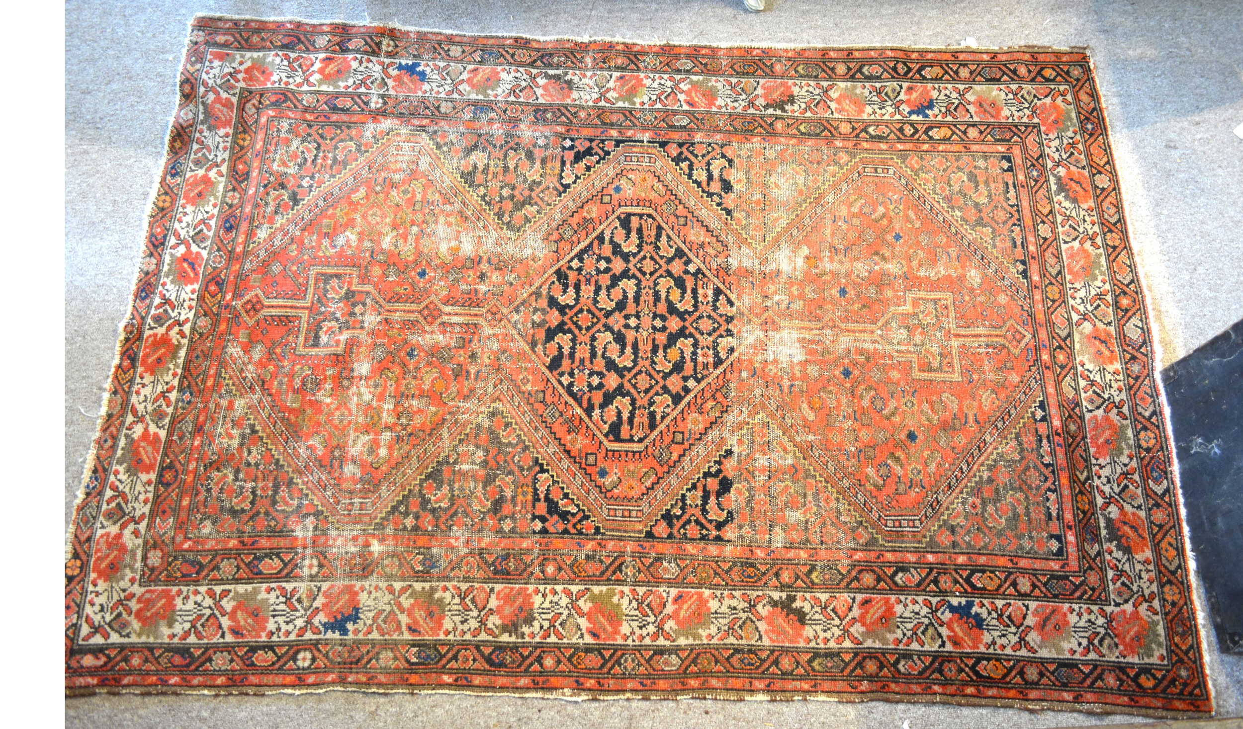 A North West Persian woollen rug with a central medallion within an all over design upon a red, blue