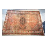 A North West Persian woollen rug with a central medallion within an all over design upon a red, blue