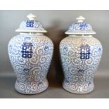 A pair of Chinese underglaze blue decorated covered vases, each with an allover foliate design,