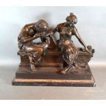 A 20th century patinated bronze group in the form of two classical figures on a bench, bearing