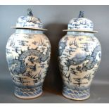 A pair of Chinese underglaze blue decorated covered floor vases, each decorated with serpents