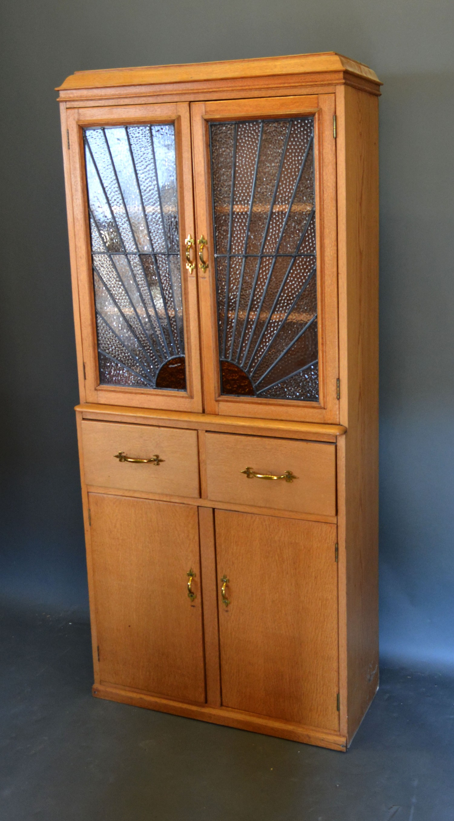 An early 20th century side cabin with two sunburst stained glass doors, the lower section with two