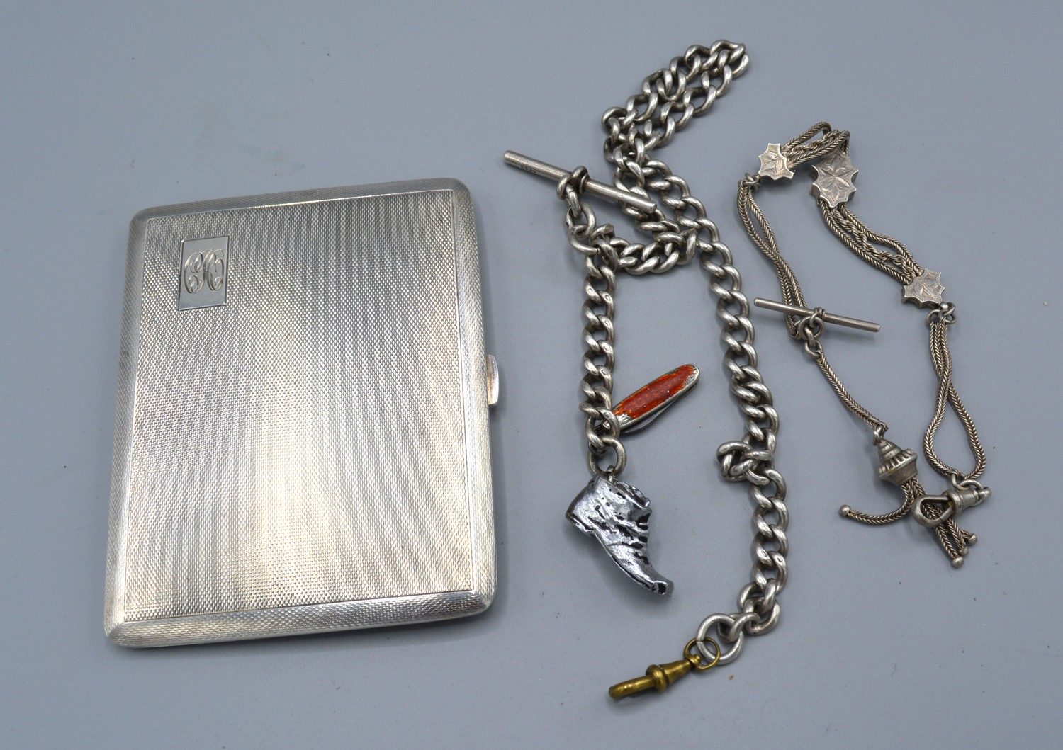 A Birmingham silver cigarette case together with two silver watch chains