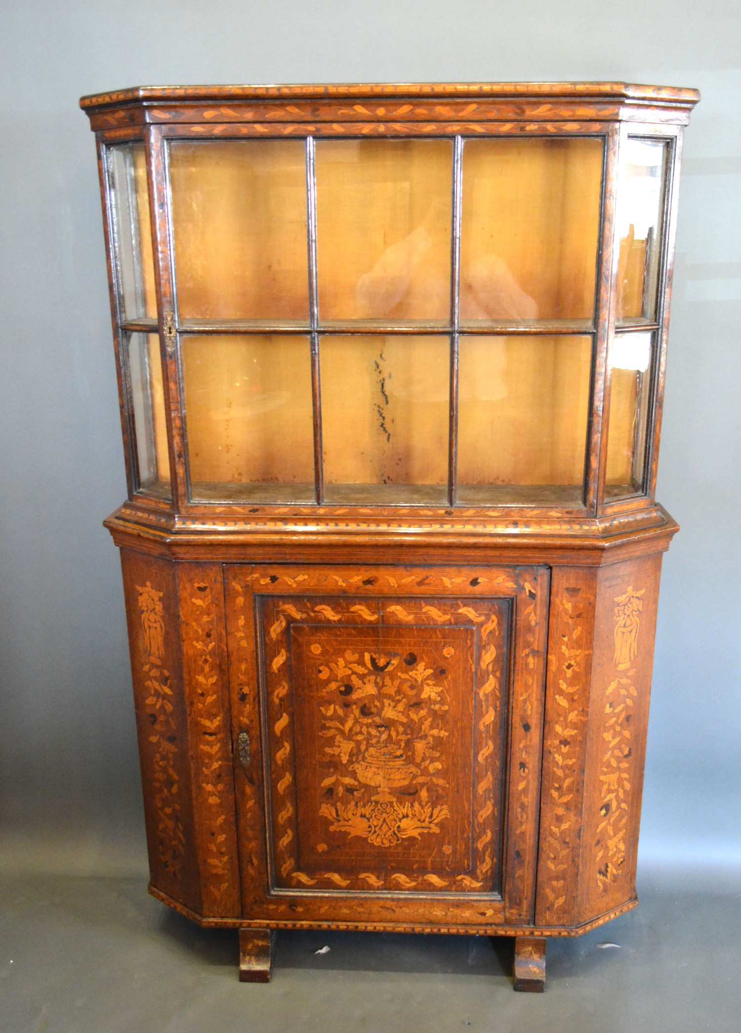 A 19th Century Dutch marquetry inlaid cabinet, the moulded top above a bar glazed door, the lower