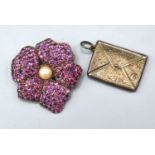 A White Metal Brooch in the form of a flower head encrusted with pink stones with central pearl