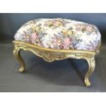 A Large French Style Stool of shaped form, the upholstered top above a carved frieze raised upon