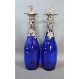 A pair silver plated and blue glass decanters, decorated with grape vine, 35cms tall