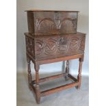 An 18th Century Oak Bible Box, the hinged top above a carved frieze, the stand with turned legs