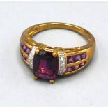 A 9ct. Gold Amethyst and Diamond Set Ring with a central amethyst flanked by diamonds and two