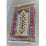 A North West Persian Woollen Prayer Rug with an all over design upon a cream red and blue ground