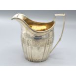 A George III silver cream jug of ribbed engraved form with reeded handle, London 1800, makers Peter,