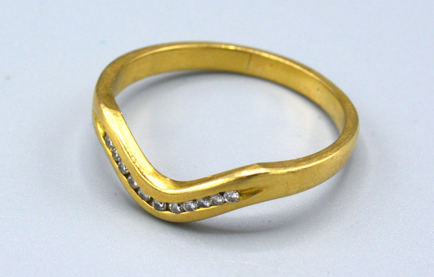 An 18ct Yellow Gold Diamond Set Ring of V Shape set with eleven diamonds, 4 gms Size U